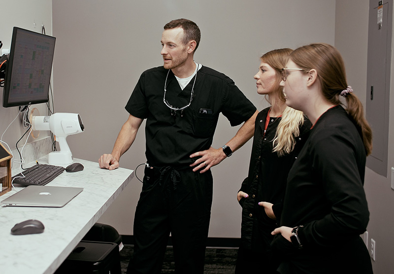 Addison showing patient charts to two members of his team